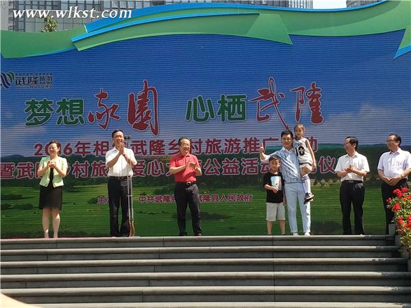 “村長”李銳為“愛心小天使”代表頒發(fā)徽章 李瓊/攝
